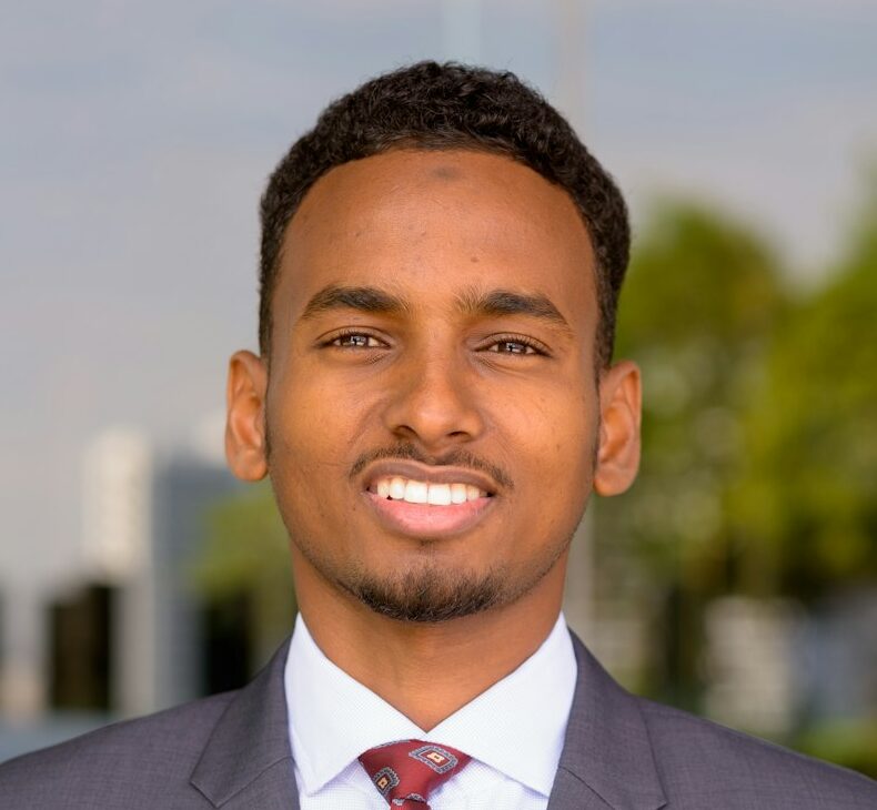 Portrait of African businessman wearing suit and tie outdoors in city while smiling
